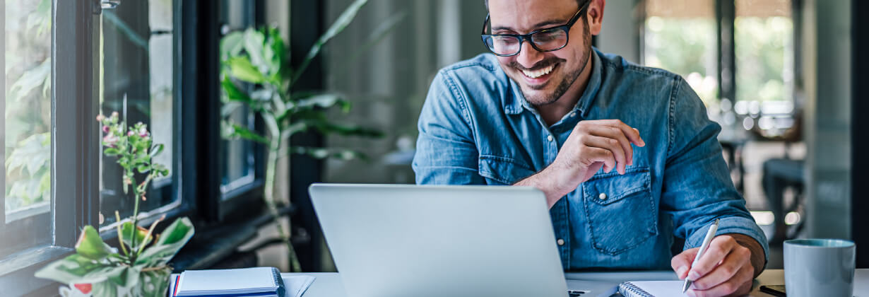 Man on laptop at home smiling