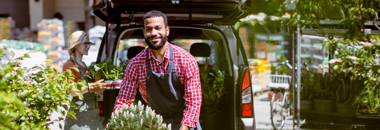 man loading flowers into car