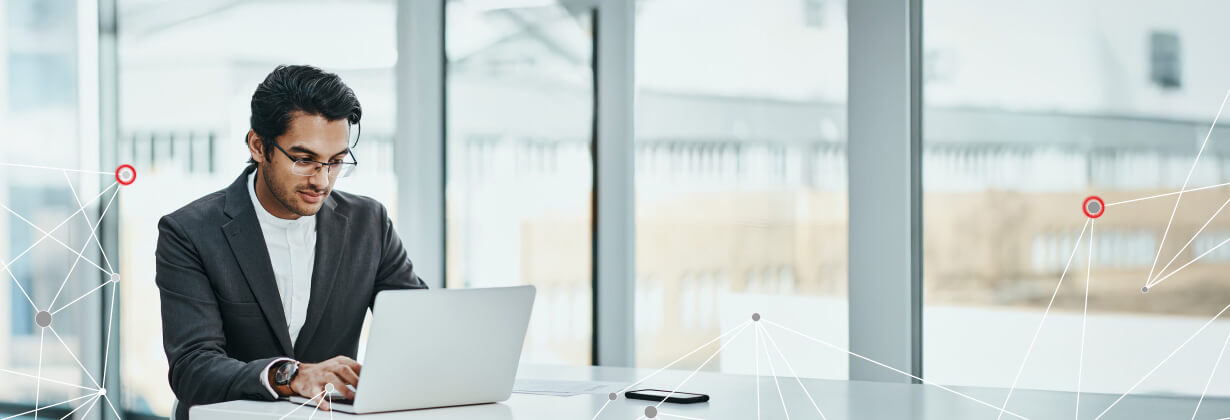 Man on laptop in front of window