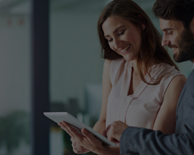 Woman showing man tablet at work