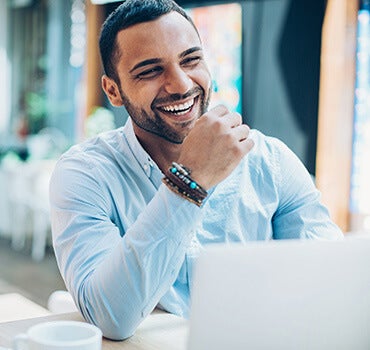 smiling man in front of laptop