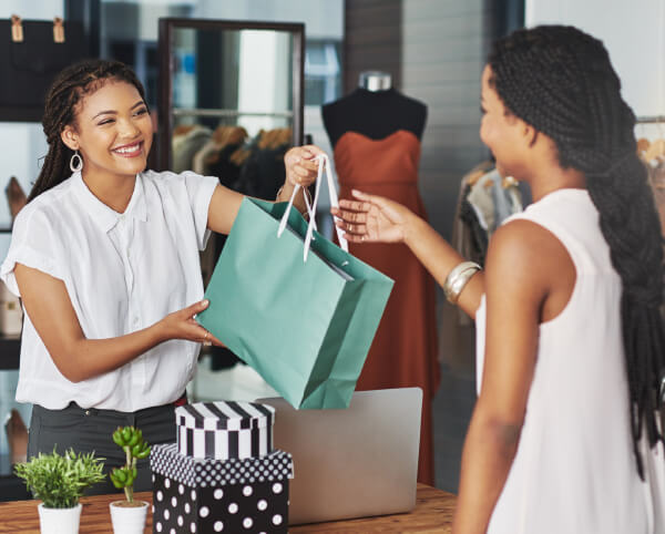 store owner handing parcel to customer
