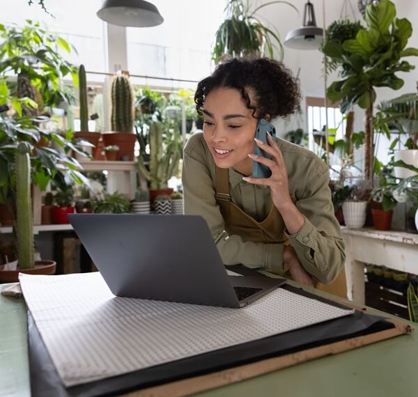woman on a laptop surrounded by plants