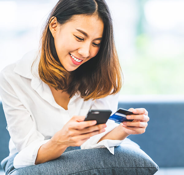 Woman looking at smart phone and credit card