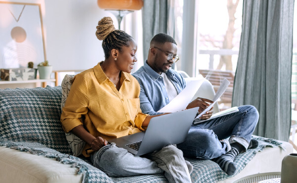 woman and man on couch doing bills