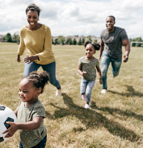 family with young children playing soccer