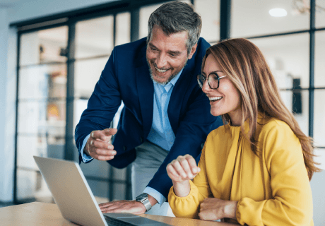 Women and man on computer smiling
